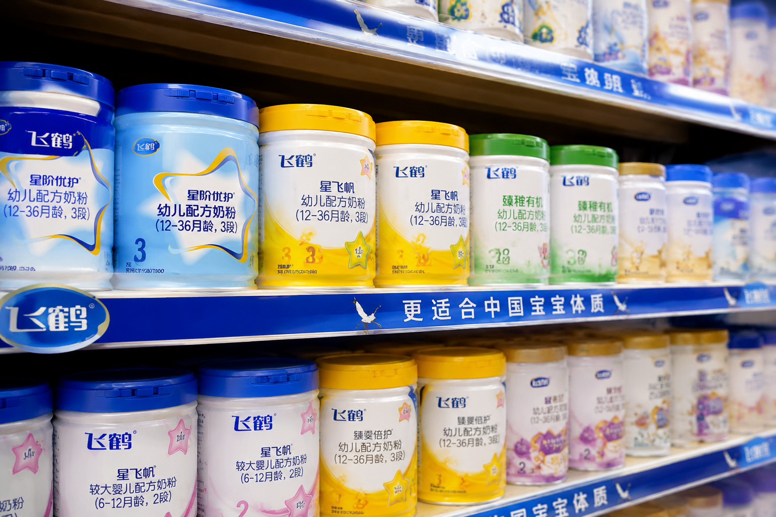 超市貨架上整齊排列著各種飛鶴品牌的奶粉，包括星階優(yōu)護(hù)、星飛帆、臻稚有機(jī)等不同系列，包裝精美，景深效果，背景略微模糊，突出品牌家族的豐富產(chǎn)品線，商業(yè)攝影。