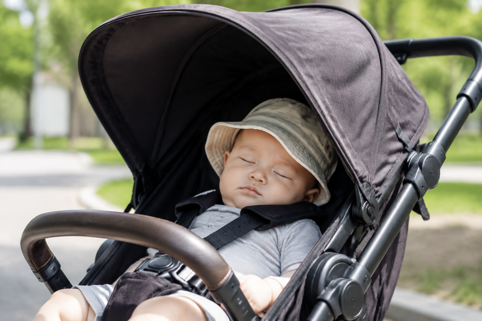 A cute 4-month-old baby sleeping peacefully in a modern stroller, wearing a soft bucket sun hat, stroller canopy fully extended blocking the soft early summer sunlight, outdoor park setting, bright and airy, natural lighting, high resolution, photorealistic photography, shot on 35mm lens, depth of field --ar 3:4 --v 6.0