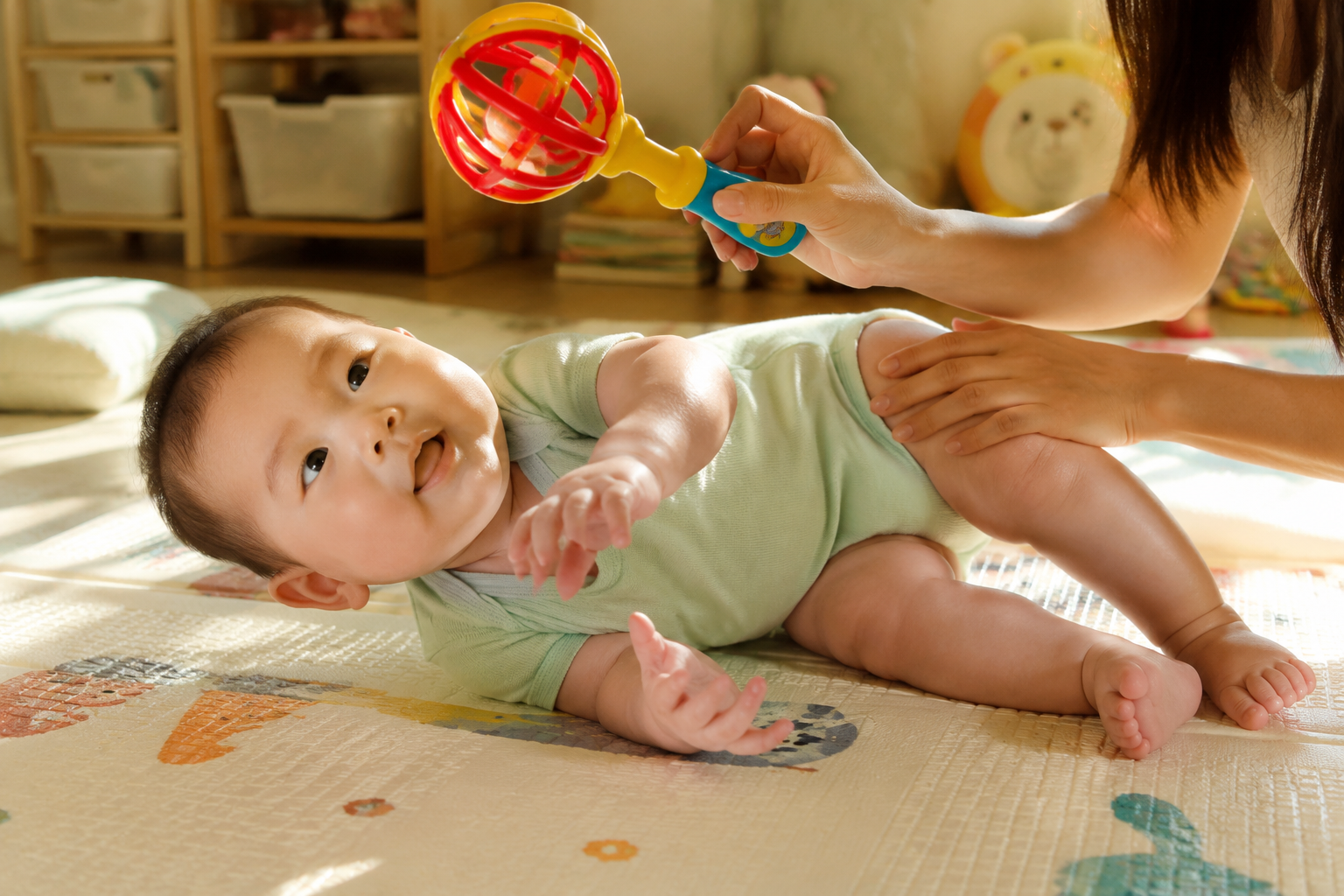 A 5-month-old Chinese baby lying on a soft play mat, attempting to roll over. A gentle young Chinese mother's hands are holding a bright rattle toy to guide the baby's gaze and lightly supporting the baby's hip. The baby is wearing a stretchy bamboo fiber summer onesie. Bright interior, warm sunlight, photorealistic, cinematic lighting, highly detailed --ar 3:4