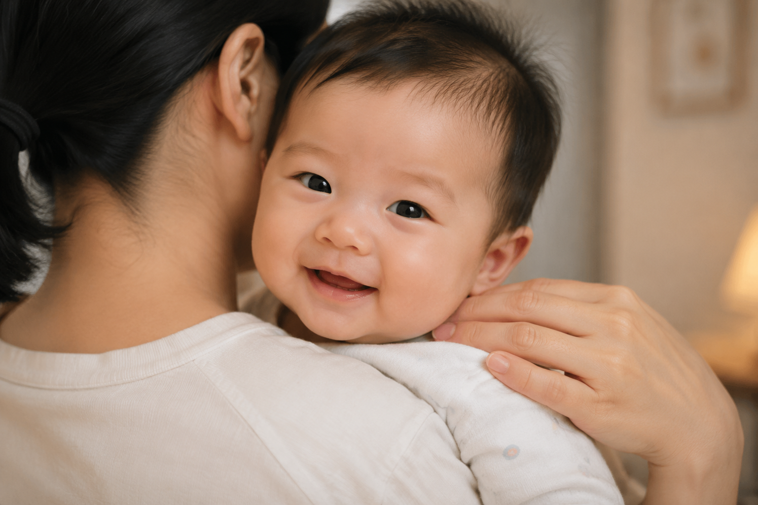 Close-up shot, a Chinese mother's gentle hand touching the back of her baby's neck to check the temperature. The baby is smiling over the mother's shoulder. Warm indoor lighting, educational and caring vibe. Depth of field, high quality, realistic photography --ar 16:9