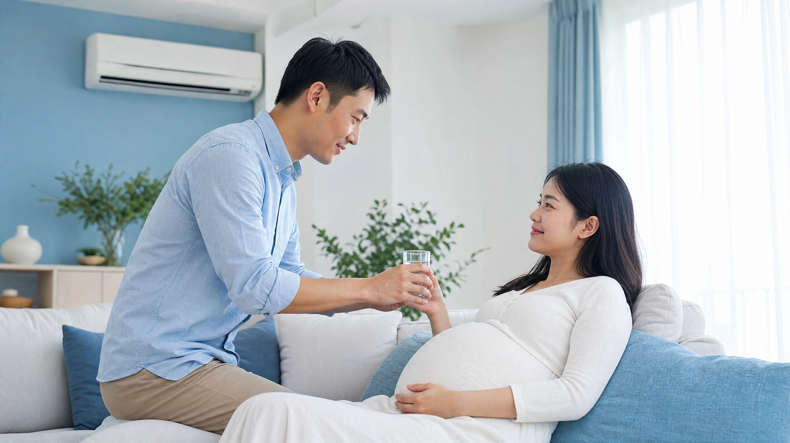 A high-quality, realistic photo of a caring Chinese husband helping his pregnant wife cool down in a comfortable, bright, air-conditioned living room. The pregnant wife is resting comfortably on a sofa, and the husband is gently handing her a glass of light saltwater. Fresh and clean blue and white medical style color palette, soft natural light, warm and reassuring atmosphere, 8k resolution, highly detailed.