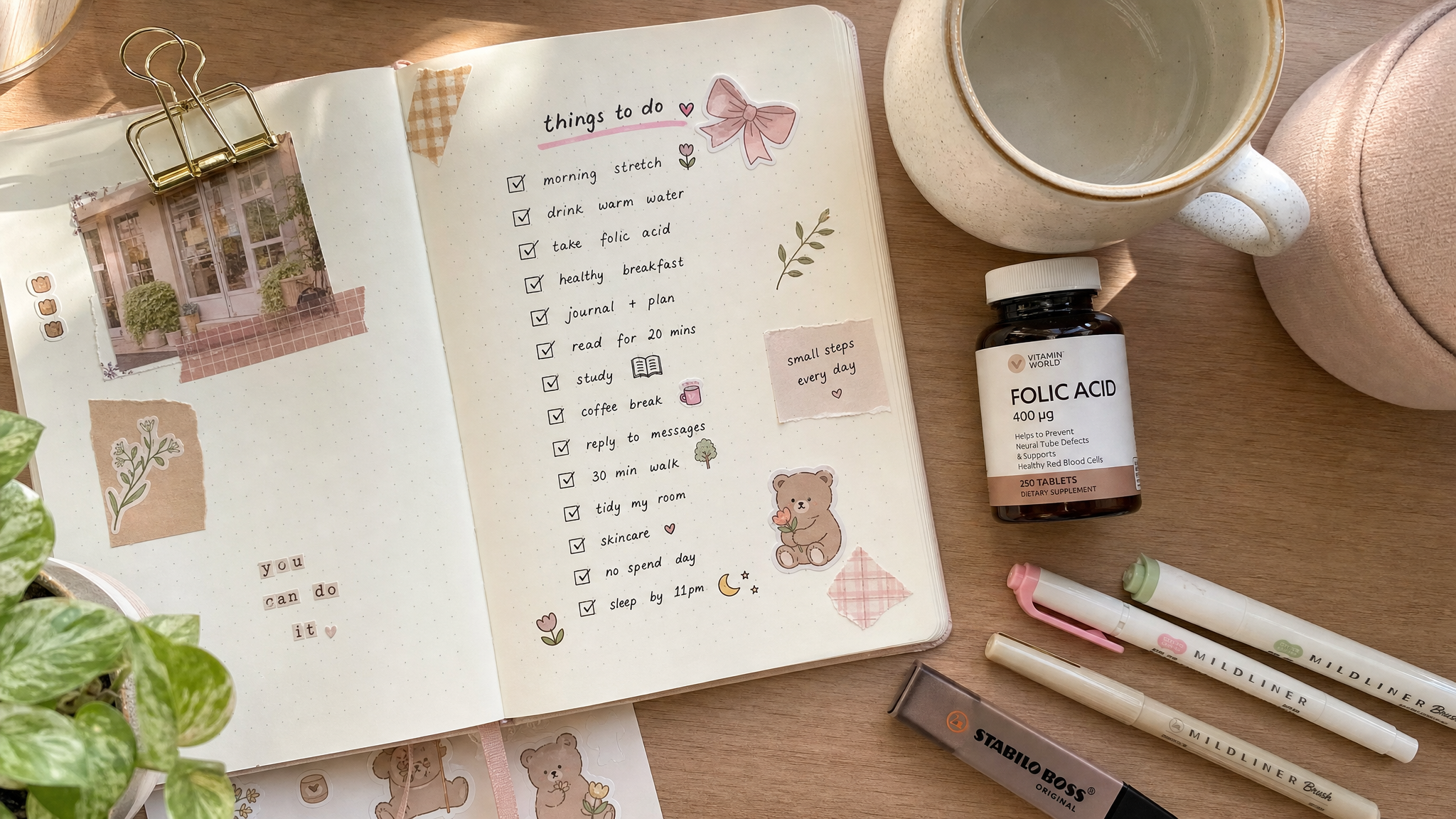 A top-down view of a cute, aesthetic bullet journal on a wooden desk. The journal has a handwritten checklist with checkmarks, decorated with pastel highlighters and small cute stickers. A cup of warm water and a small bottle of folic acid pills are next to the journal. Cozy, bright natural lighting, soft focus, highly detailed, Pinterest style.