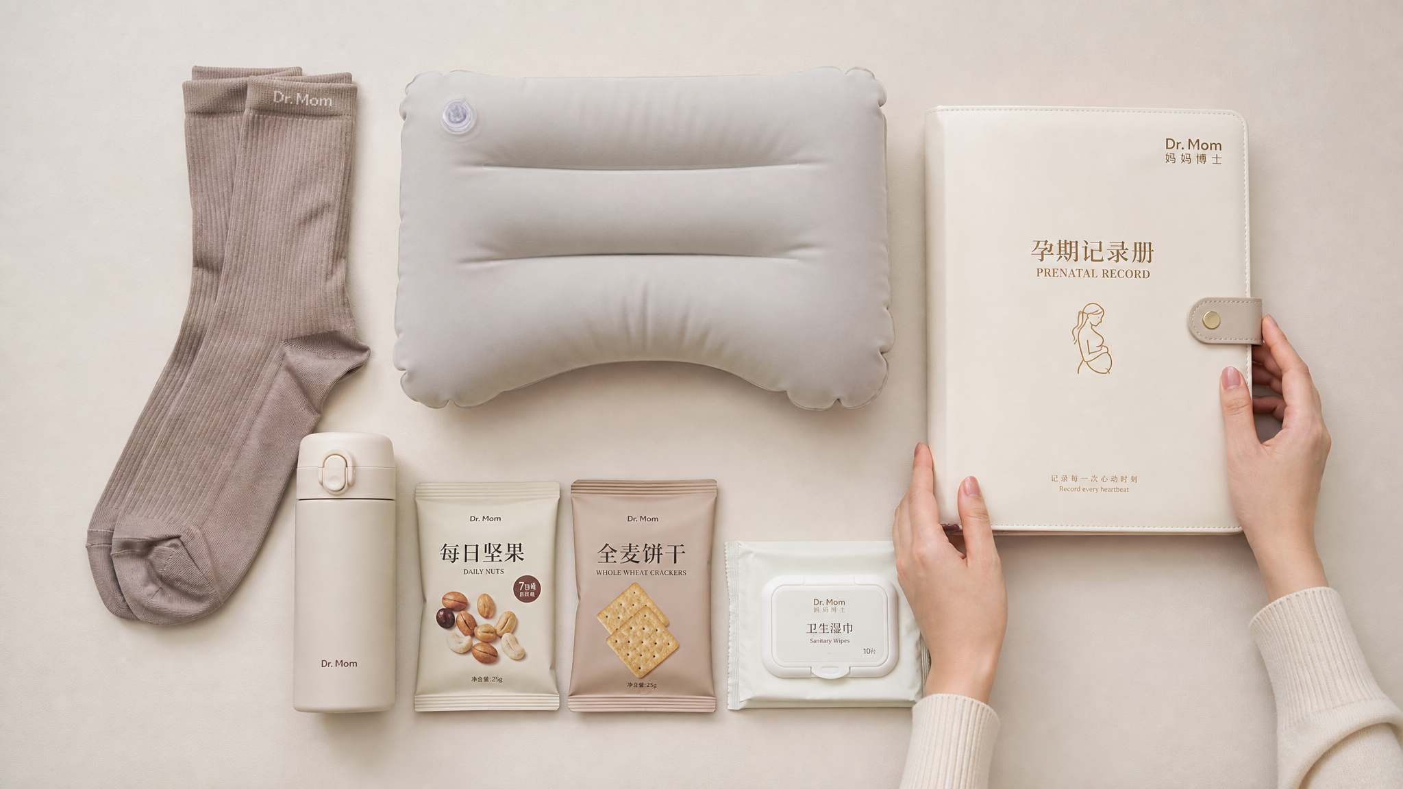 A minimalist flat lay photography of a pregnancy travel kit on a clean neutral light beige background, arranged by a pair of elegant hands of a Chinese woman. Includes a pair of compression socks, an inflatable lumbar pillow, a thermos, small packs of mixed nuts, whole wheat crackers, wet wipes, and a prenatal record folder. Neatly organized, soft studio lighting, high resolution, photorealistic, premium lifestyle aesthetic. --ar 3:4
