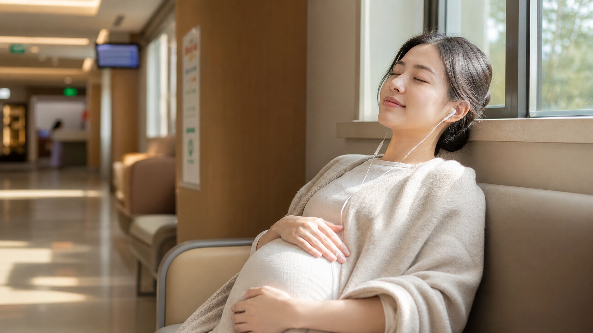 A photorealistic image of a young Chinese pregnant woman sitting in a hospital waiting area. She is wearing a light, cozy shawl and white earphones, looking peaceful and relaxed with her eyes slightly closed. Soft, warm natural light coming from a nearby window. High quality, cinematic lighting, shot on 35mm lens, Midjourney v6. --ar 3:4