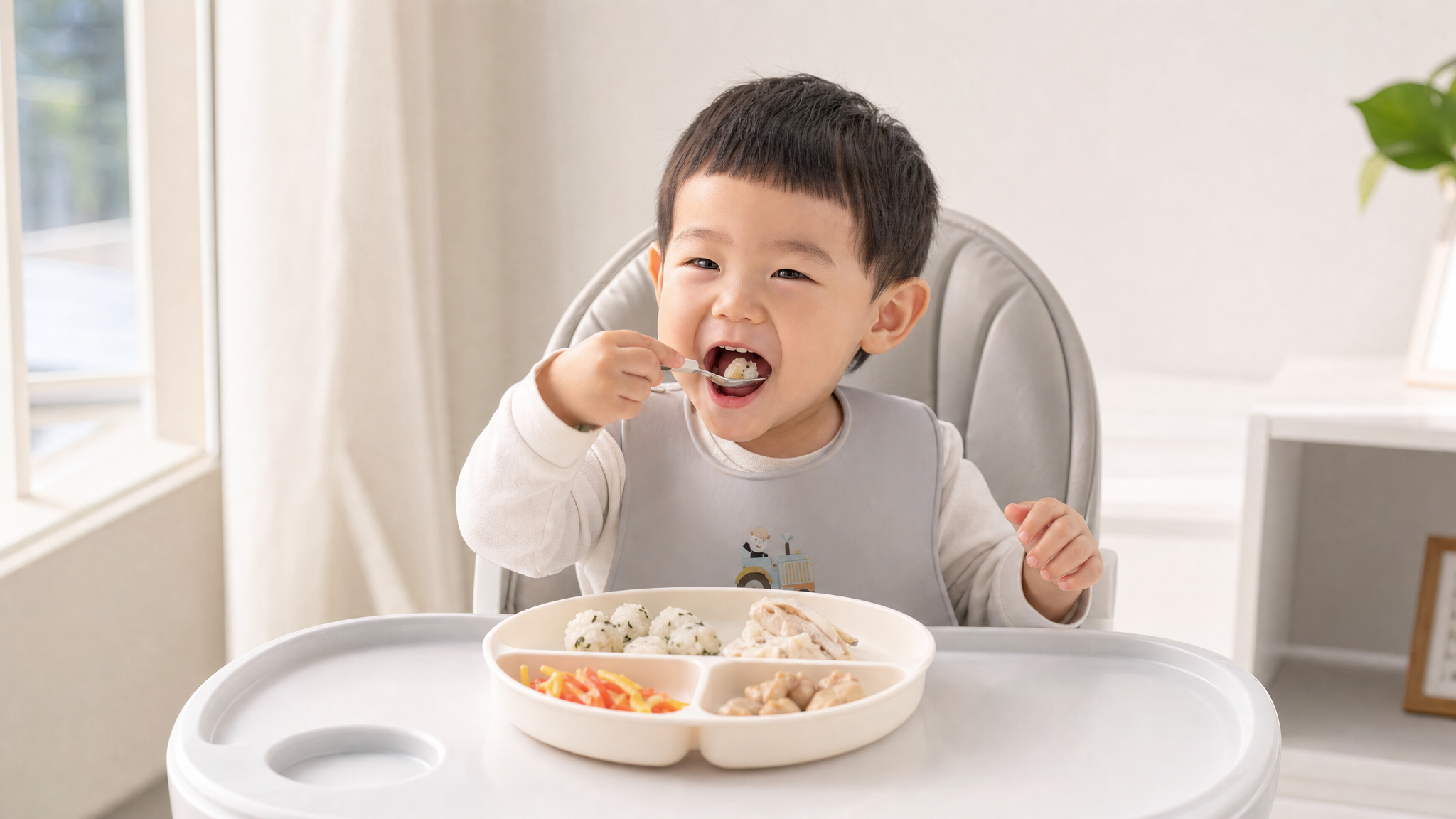 A cute 2-year-old Chinese toddler sitting in a high chair, happily eating by himself. On the table is a divided plate with small portions of steamed fish, shredded bell peppers, and small rice balls. Soft natural sunlight coming from the window, clean white and light gray background, bright and warm tone, commercial photography, 8k, photorealistic.
