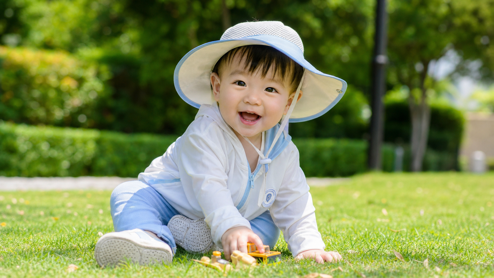 A cute 1-year-old Chinese toddler playing on a sun