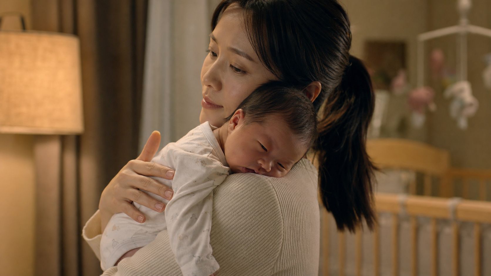 A gentle Chinese mother holding her newborn baby a