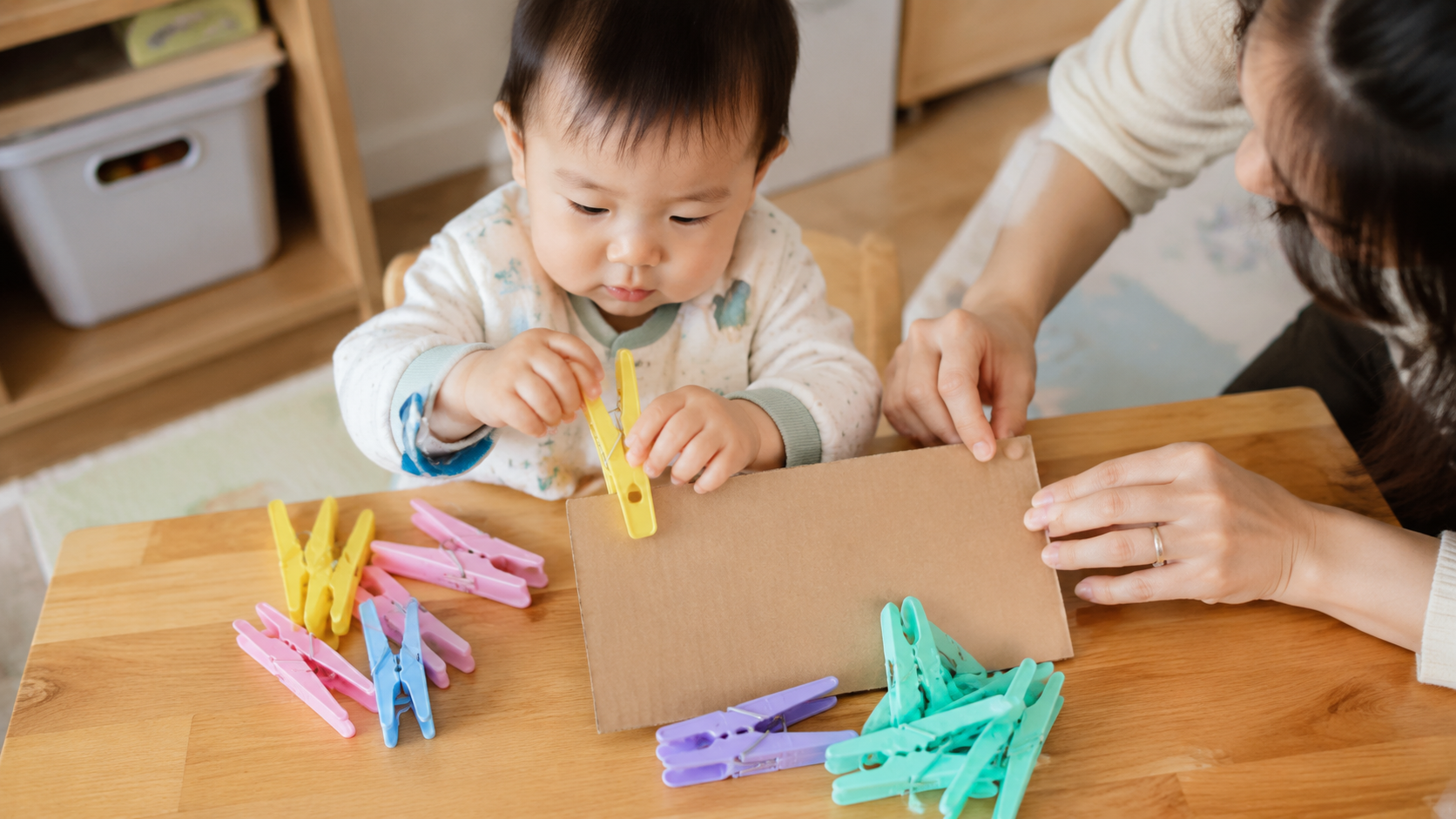 A cute 1-year-old Chinese baby sitting at a low wo
